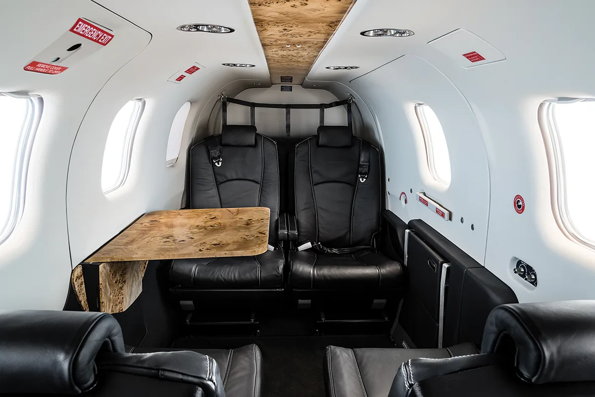 Daher TBM 850 cabin interior with leather seats and a wood-finish folding table